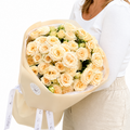 Bouquet of cream-colored roses held by a person on a white background