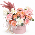 Floral arrangement in a pink box with 'The Flower Bar' branding on a white background