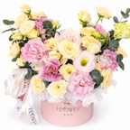 Colorful bouquet of flowers in a pink box with 'The Flower Bar' branding on a white background